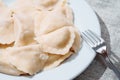 Serving of traditional Polish pierogy dish on a white plate. Dumplings filled with meat, cheese and mushrooms. Popular Eastern