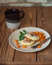 Serving of two cottage cheese pancakes with sea buckthorn ice cream on a ceramic brown plate and brown coffee beans Royalty Free Stock Photo