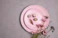 Serving of two pink plates with beautiful small quail eggs, a feather and a branch of a wildflower Royalty Free Stock Photo