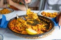 serving typical Spanish paella with mussels and clams in restaurant