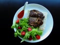 Serving white plate with crispy fried meat, vegetables, thin bread and sauce on black surface Royalty Free Stock Photo