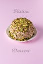 Sesame halva with pistachios on pink with Halva dessert text