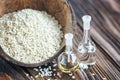 Sesame oil in a glass bottle and heap sesame seeds in coconut shell on wooden rustic table. Selective focus. Royalty Free Stock Photo