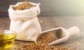 Sesame seeds in sack and bottle of oil on wooden rustic table on sunlight Royalty Free Stock Photo