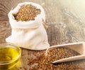 Sesame seeds in sack and bottle of oil on wooden rustic table on sunlight Royalty Free Stock Photo