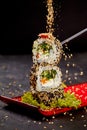 Sesame seeds sprinkling on vegetarian sushi roll tower Royalty Free Stock Photo