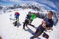 Group of alpinists selfie on mountain top. Scenic high altitude background on snow capped Alps, sunny day.