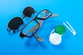 A set of accessories for sight. Pinhole glasses, lenses with container and glasses for sight. Pair of medical pinhole glasses with