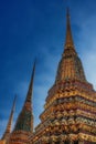 Set against a pristine blue sky, the Temple of the Emerald Buddha boasts three majestic decorated Buddhist stupas, their spires