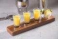 Set of alcoholic cocktails in shot glasses with pineapple slices on wooden board Royalty Free Stock Photo