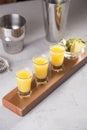 Set of alcoholic cocktails in shot glasses with pineapple slices on wooden board Royalty Free Stock Photo