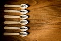 A set of alined wooden spoons laying on a wooden surface each spoon is hand written with the word Royalty Free Stock Photo