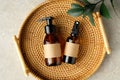 Set of amber glass bottles of natural cosmetics for personal hygiene in rattan tray. SPA organic beauty products top view