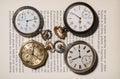 A set of antique gold and silver pocket watches lying on the pages of an open book. Round old clock with white dials Royalty Free Stock Photo