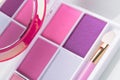 Set for applying makeup: a palette of pink eyeshadows with a brush and a mirror, close-up Royalty Free Stock Photo