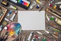 Set of artist accessories collection. Canvas, tube of oil paint, art brushes, palette knife lying on the wood table. Artist works Royalty Free Stock Photo