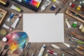 Set of artist accessories collection. Canvas, tube of oil paint, art brushes, palette knife lying on the wood table. Artist works Royalty Free Stock Photo