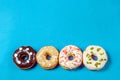 Set of assorted donuts with blue glaze, sprinkle, almond crumbs, chocolate and marshmallows close-up isolated on a purple Royalty Free Stock Photo