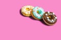 Set of assorted donuts with blue glaze, sprinkle, chocolate and marshmallows close-up isolated on a pink background. Sweet food Royalty Free Stock Photo