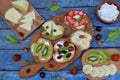 Set of assorted healthy wholewheat bread sandwiches with fruit, cheese and leafy green herbs on picnic wooden table. Ciabatta sand