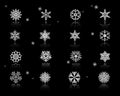 Set of assorted white snowflakes icons on black background with sparks