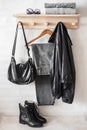 Set of autumn women`s clothing on a wooden hanger - gray mom`s jeans, a black windbreaker, high leather shoes, a pullover, a bag Royalty Free Stock Photo