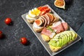 A set of avocado sandwiches, cherry tomatoes and eggs, figs, prochutto on a stone background Royalty Free Stock Photo
