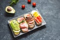 A set of avocado sandwiches, cherry tomatoes and eggs, figs, prochutto on a stone background. Royalty Free Stock Photo