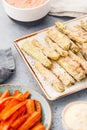 Set of baked season vegetable sticks with sauce and hummus