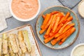 Set of baked season vegetable sticks of zucchini and carrots with sauce and hummus