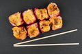 Set of baked sushi rolls with chopsticks on black stone table background. Baked sushi roll isolated. Traditional japanese food Royalty Free Stock Photo