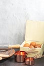 Set of baking utensil and copper measuring cups with eggs in vintage kitchen style in front view Royalty Free Stock Photo
