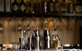 Set of bar accessories for making cocktails, located on the bar, behind is a shelving with liqueurs and strong alcohol. Royalty Free Stock Photo