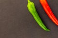 Set base vegetable pair of bright chili peppers red green mature juicy contrast on a dark background