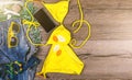 Set of beach clothes yellow bikini, bracelets, jeans shorts, glasses on dark wooden background. Top view. Summer Holiday Royalty Free Stock Photo