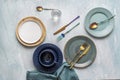 Set of beautiful colored plates with blue cloth and iridescent and gold cutlery