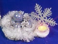 set beautiful glass poured New Year`s balls, brilliant tinsel, the burning candle and a snowflake on a blue background - New Year` Royalty Free Stock Photo