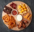 Set of beer snacks. Consisting of spicy chicken wings, french fries, cheese sticks, squid in batter, croutons and fried Bavarian Royalty Free Stock Photo