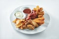 Set of beer snacks - sausages, croutons, mozzarella fries and chips with sauces on a white plate on a white plate. Pub food