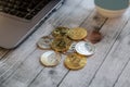 Set of the best cryptocurrencies, bitcoin, ethereum, ripple, iota, litecoin, dash, monero on a table next to a laptop and a blue