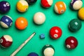 Set of billiard balls with cue and chalk on green table, flat lay Royalty Free Stock Photo