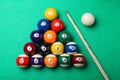 Set of billiard balls and cue on green table, flat lay Royalty Free Stock Photo