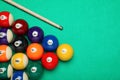 Set of billiard balls and cue on green table, flat lay. Space for text Royalty Free Stock Photo