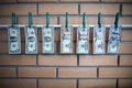 Concept of money laundering - dollars are drying on lath on on brick wall background Royalty Free Stock Photo