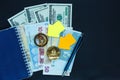 Set of bitcoin, ethereum - crypto currency with yellow paper arrows next to notepad on real money background.