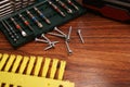 A set of bits and mounting screws on a dark wooden table.