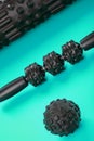 A set of black bumpy foam massage rollers, body rollers, rubber balls on a blue background Royalty Free Stock Photo