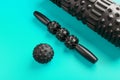 A set of black bumpy foam massage rollers, body rollers, rubber balls on a blue background Royalty Free Stock Photo