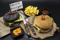 Set of the black burger and classical American burger . Black burger roll slices of juicy marble beef, fused cheese, fresh salad w Royalty Free Stock Photo