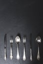 Set of black cutlery: fork, spoon, and knife. Placed over black background, table setting. Copy space banner Royalty Free Stock Photo